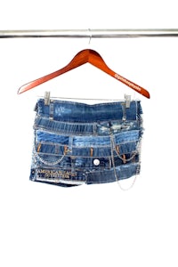 a blue denim skirt hanging on a hanger